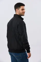 Campera liviana de nylon color azul marino, con cuello alto, cierre frontal y puños y dobladillo en elástico tejido.