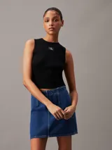 Musculosa Calvin Klein de corte slim, confeccionada en tejido de punto de canalé suave y elástico. Presenta cuello redondo, diseño sin mangas y una insignia con el monograma de la marca en el pecho.