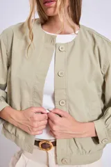 Cazadora azul de manga larga con puños elásticos, cuello redondo sin solapas y cierre frontal con botones grandes de color claro.