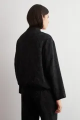 Chaqueta bomber de corte recto en tejido jacquard con estampado floral en tono sobre tono negro, cuello mao y cierre frontal de broches a presión.