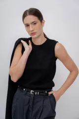 Chaleco negro tejido en alpaca, sin mangas y con cuello redondo. Corte recto y textura suave.