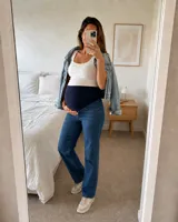 Jean maternal recto de denim azul clásico con lavado suave, de corte holgado y diseño con faja maternal alta y flexible.