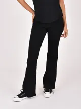 Jean negro de corte flare, con tiro medio y diseño clásico de cinco bolsillos.