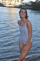 Malla enteriza color lila con escote redondo y costuras verticales decorativas en color verde oliva.