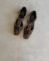 Mocasín negro de cuero vacuno, con punta cuadrada y detalle de borlas en el empeine.