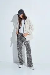 Canguro de corderito con capucha, cierre frontal y bolsillos laterales. Diseño relajado y textura suave.