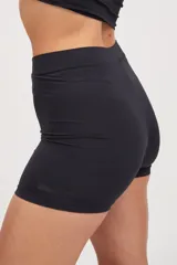 Calza corta negra ajustada al cuerpo, tiro medio, confeccionada en tejido suave con protección UV50+ y logo estampado al tono.