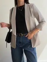 Blazer sastrero de diseño clásico con solapas frontales, corte recto y mangas largas. Confeccionado en tela con caída fluida y completamente forrado en su interior.