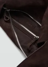 Bolso grande de serraje de piel bovina color marrón oscuro, con diseño estilo shopper y asa de hombro. Cuenta con cierre de cremallera y forro interior de algodón.