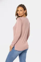 Buzo de tejido de punto fino en color rosado, con cuello redondo y mangas largas. Presenta un delicado bordado de pequeñas flores dispersas por toda la prenda.