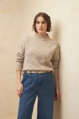 Polera beige de tejido de punto con cuello alto y mangas largas.