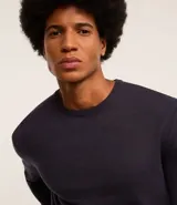 Suéter de punto color borgoña, con cuello redondo, sisas ligeramente desplazadas y bajo y puños acanalados.