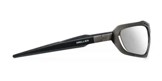 Lentes de sol envolventes con montura de acero inoxidable en acabado plateado cepillado y lentes de nylon espejadas. Presentan un diseño vanguardista con aberturas decorativas en la parte superior del marco.