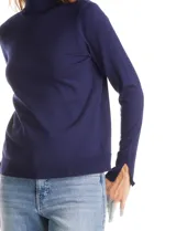 Polera de tejido fino con cuello alto, manga larga y detalle de tajo en los puños.