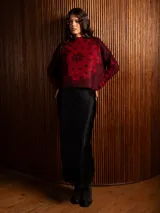 Buzo de punto de manga larga con cuello redondo, confeccionado en un tejido suave de textura peluda. Presenta un diseño estampado con motivos florales y ornamentales en color negro sobre una base de color rojo intenso.