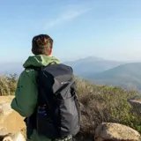 Mochila Columbia Triple Canyon color negro, diseñada para senderismo, con capacidad de 24 litros, panel trasero de malla transpirable, tirantes acolchados, cinturón ajustable, funda impermeable y compartimento compatible con hidratación.