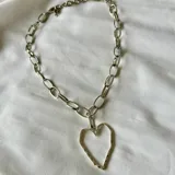 Collar plateado con cadena de eslabones y dije de corazón calado.