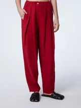 Pantalón sastrero rojo con elástico en la cintura, bolsillos delanteros, tiro medio y corte recto. Cierra con botón.