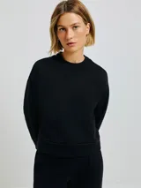 Buzo negro de algodón con cuello redondo y corte holgado.