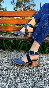 Zapatos de tacón ancho color camel con textura símil serpiente, punta fina y tiras cruzadas con hebilla metálica grande en el lateral.