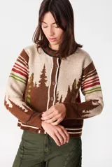 Cardigan de punto con diseño de bosque de pinos y detalles a rayas en las mangas. Cuenta con cuello redondo y cierre frontal de botones.