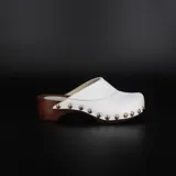 Suecos blancos con base de madera de álamo, realizados en napa de primera calidad y forrados en cuero. La base de madera es anatómica y liviana, con fondo de goma. La capellada está doblemente clavada.