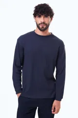 Buzo de manga larga con textura tipo waffle, cuello redondo y corte holgado.