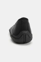 Zapato tipo bailarina deportiva de color negro, con suela de goma y detalle de lazo en la puntera redonda.