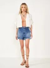 Short de jean azul con tachas doradas, tiro alto y ruedo doblado.