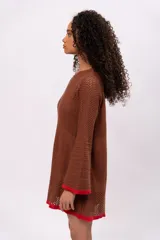 Vestido tejido calado color marrón con mangas acampanadas y terminaciones en rojo. Incluye forro interior desmontable.
