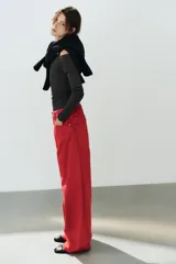Jeans estilo baggy oversize de tiro medio en color rojo, con cinco bolsillos, trabillas para cinto y costuras decorativas marcadas en las piernas.