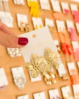 Aros caravanas dorados con diseño de flores texturizadas.