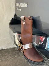 Bota de cuero marrón con estribo desmontable plateado.