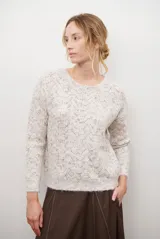 Buzo de punto con cuello redondo, manga larga y textura jaspeada en tonos beige y crema.