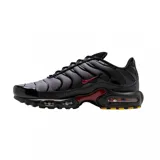 Championes Nike Air Max Plus con diseño degradado de gris a negro, estructura de soporte ondulada, logo Swoosh en rojo y unidades de aire visibles en la entresuela.