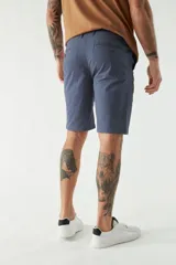 Bermuda tipo chino de gabardina con cierre de cremallera y botón, bolsillos laterales y traseros, y pasacintos en la cintura.