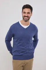 Suéter de punto color azul marino con cuello en V y manga larga. Se lleva sobre una remera blanca con cuello en V.