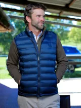 Chaleco Puffer azul marino matelaseado, con cuello alto y cierre frontal completo.