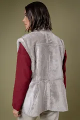 Chaleco reversible de cuero negro con interior de piel sintética gris. Presenta cierre frontal completo y bolsillos laterales con cierre.