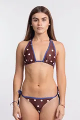 Conjunto de bikini color marrón con estampado de lunares blancos y ribetes en color azul. El top es de estilo triangular con tiras para atar al cuello y espalda, mientras que la bombacha es de corte clásico con tiras laterales ajustables.