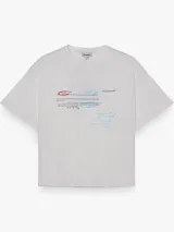Remera boxy de manga corta, color blanco, con cuello redondo y estampa tipográfica en el frente con textos y tachados en tonos rojo y celeste.