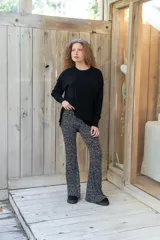 Pantalón oxford negro con estampado de pequeñas motas blancas, tiro alto y diseño ajustado con botamanga acampanada.