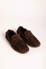 Mocasines de gamuza color marrón con diseño clásico de antifaz y costuras reforzadas en la puntera.