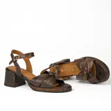 Sandalias de cuero color dorado, con plataforma y taco cuadrado. Presentan tiras cruzadas en el empeine y pulsera al tobillo con hebilla.