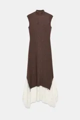 Vestido largo de cuello perkins y diseño sin mangas, confeccionado en tejido de punto color marrón. Presenta un bajo con corte evasé y detalle de encaje en color crudo a contraste. Cierre posterior con cremallera oculta.