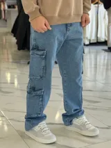 Pantalón cargo de jean azul claro, con corte oversize y múltiples bolsillos laterales en las piernas.