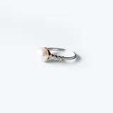 Anillo de plata 925 con una perla de río central y engarce de circonias en los laterales.