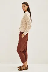 Pantalon estilo babucha color mostaza, con cintura elástica y cordón de ajuste. Presenta bolsillos diagonales en el frente y corte ligeramente ajustado hacia los tobillos.