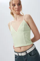 Top negro con estampado de cuadros blancos, escote en V y mangas largas.