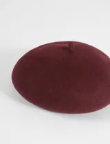 Boina clásica de estilo francés, confeccionada en tejido de poliéster con acabado afelpado.